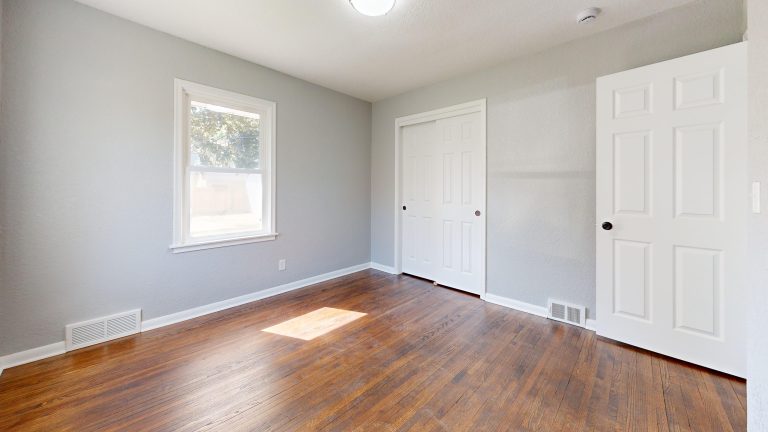 Freshly refinished hardwood flooring in an empty sunlit Alabama room