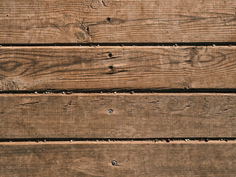 Close-up of natural wooden planks showcasing unique grain and texture, perfect as a background