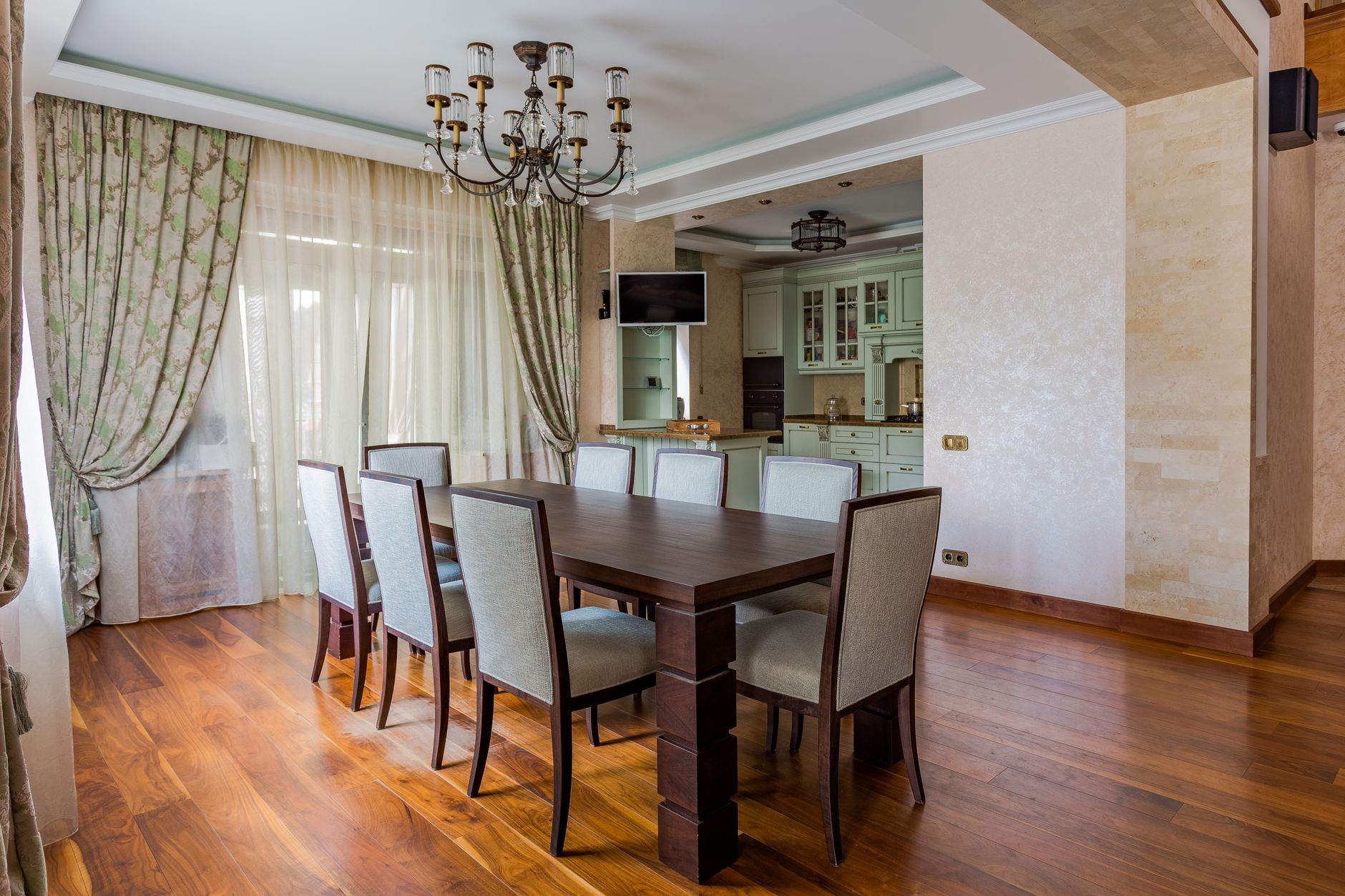 Spacious dining room with a dark wooden table, elegant chairs, and ambient lighting